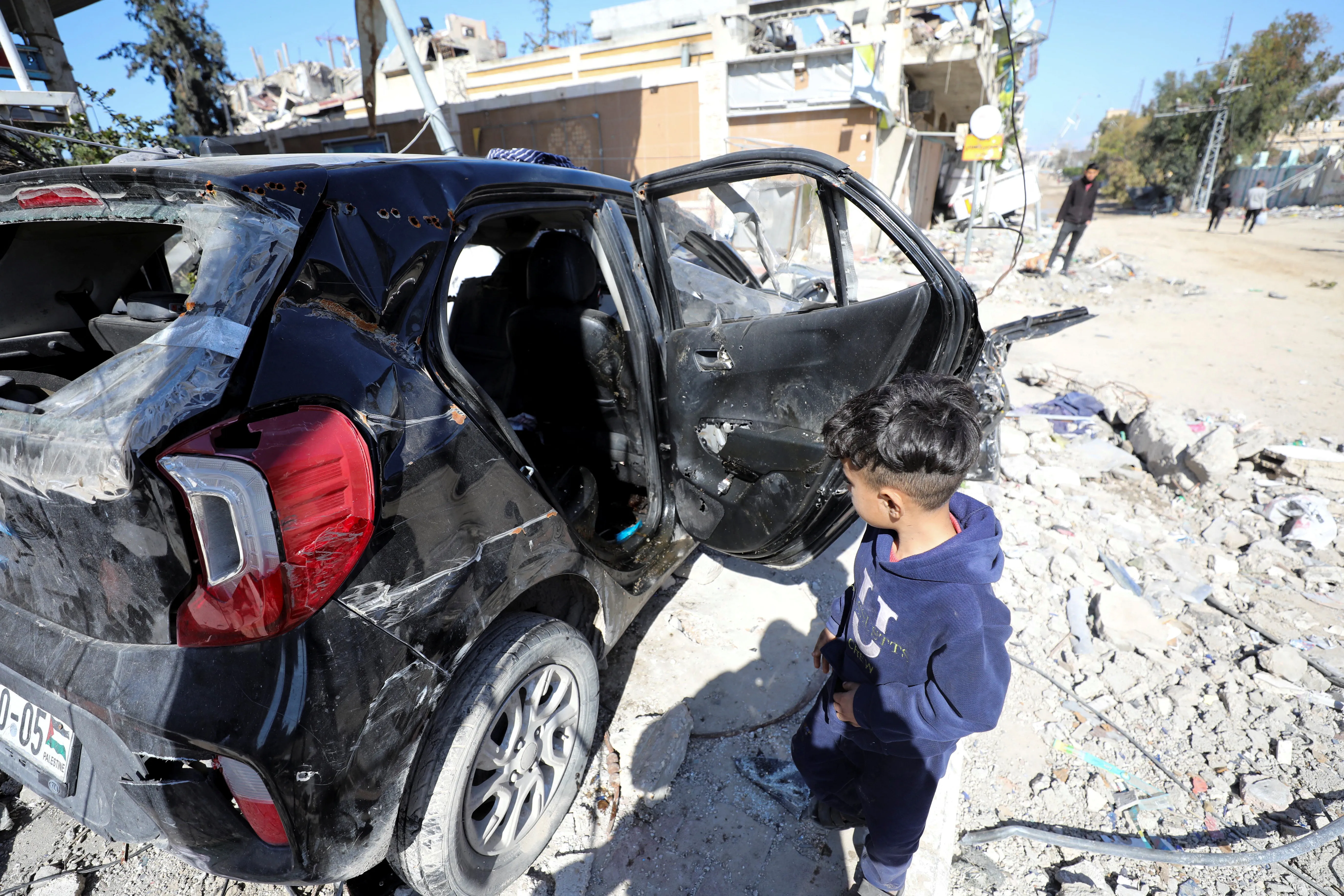 A child walks past the Hamada family car in Gaza City after it was found
